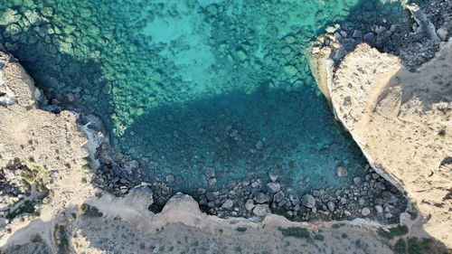 High angle view of rocks on sea shore