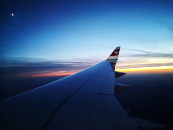 Airplane flying in sky at sunset