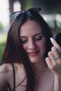 Smiling young woman with sunglasses on head