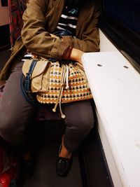 Low section of man sitting with umbrella