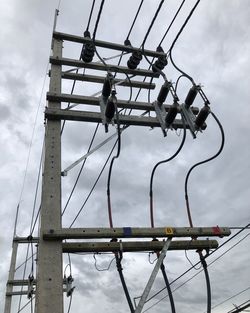 Low angle view of electricity pylon against sky