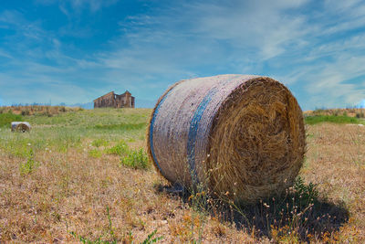 Hay bales on field against sky