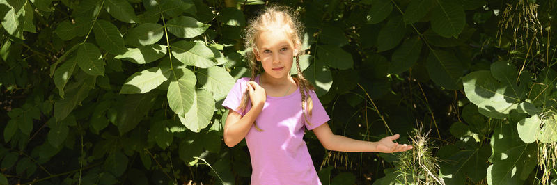 Girl standing by leaves