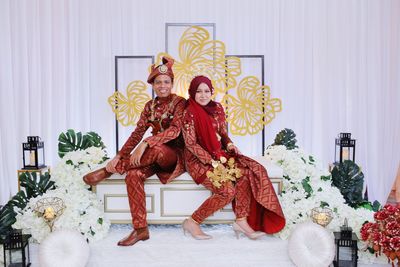 Portrait of smiling newlywed couple sitting at wedding ceremony