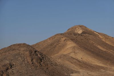 Low angle view of desert against clear blue sky