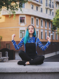 Portrait of young woman using mobile phone in city