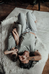 High angle view of woman lying on bed at home