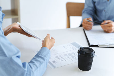 Midsection of man using laptop on table
