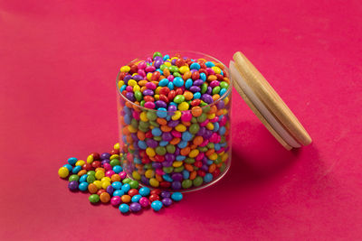 Colorful chocolate candy's, sugar coated chocolate gems candy on colorful background.