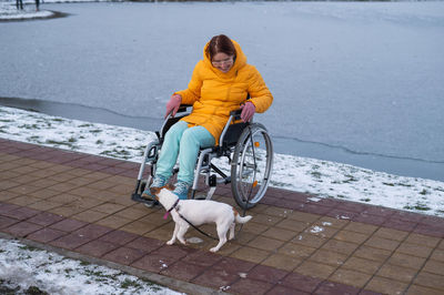 Rear view of woman sitting on street