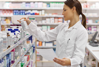 Young pharmacist standing in pharmacy