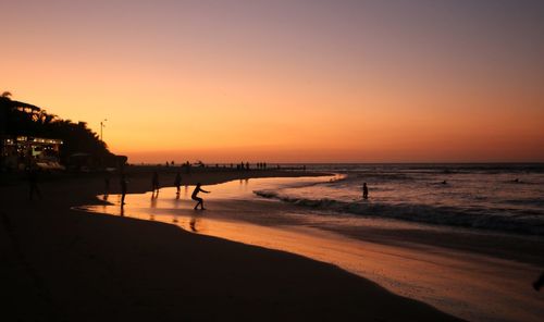 Scenic view of beach against clear sky during sunset