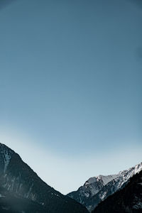 Low angle view of mountains against clear blue sky