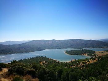 Scenic view of lake against clear blue sky