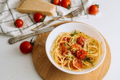 Close up portion of spaghetti pasta with parmesan and cherry tomatoes sprinkled with spices