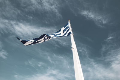 Low angle view of flag against cloudy sky