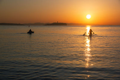 Silhouette boat in sea against sky during sunset