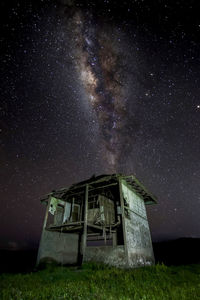 Abandoned house on field against sky at night