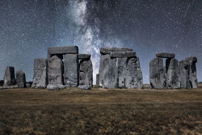 Panoramic view of rocks on field against sky at night