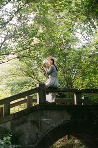 Young woman sitting on tree