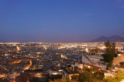 Illuminated cityscape against sky at night