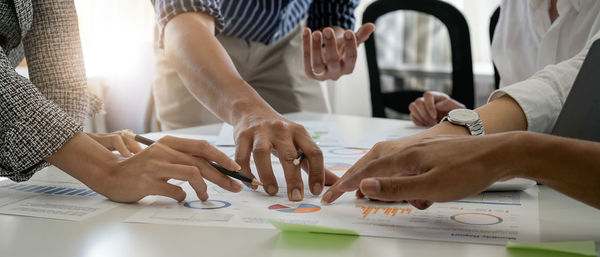 Midsection of business people working at office