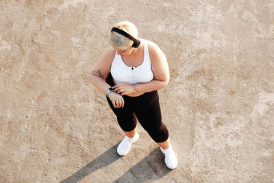 High angle view of woman wearing headphone standing outdoors