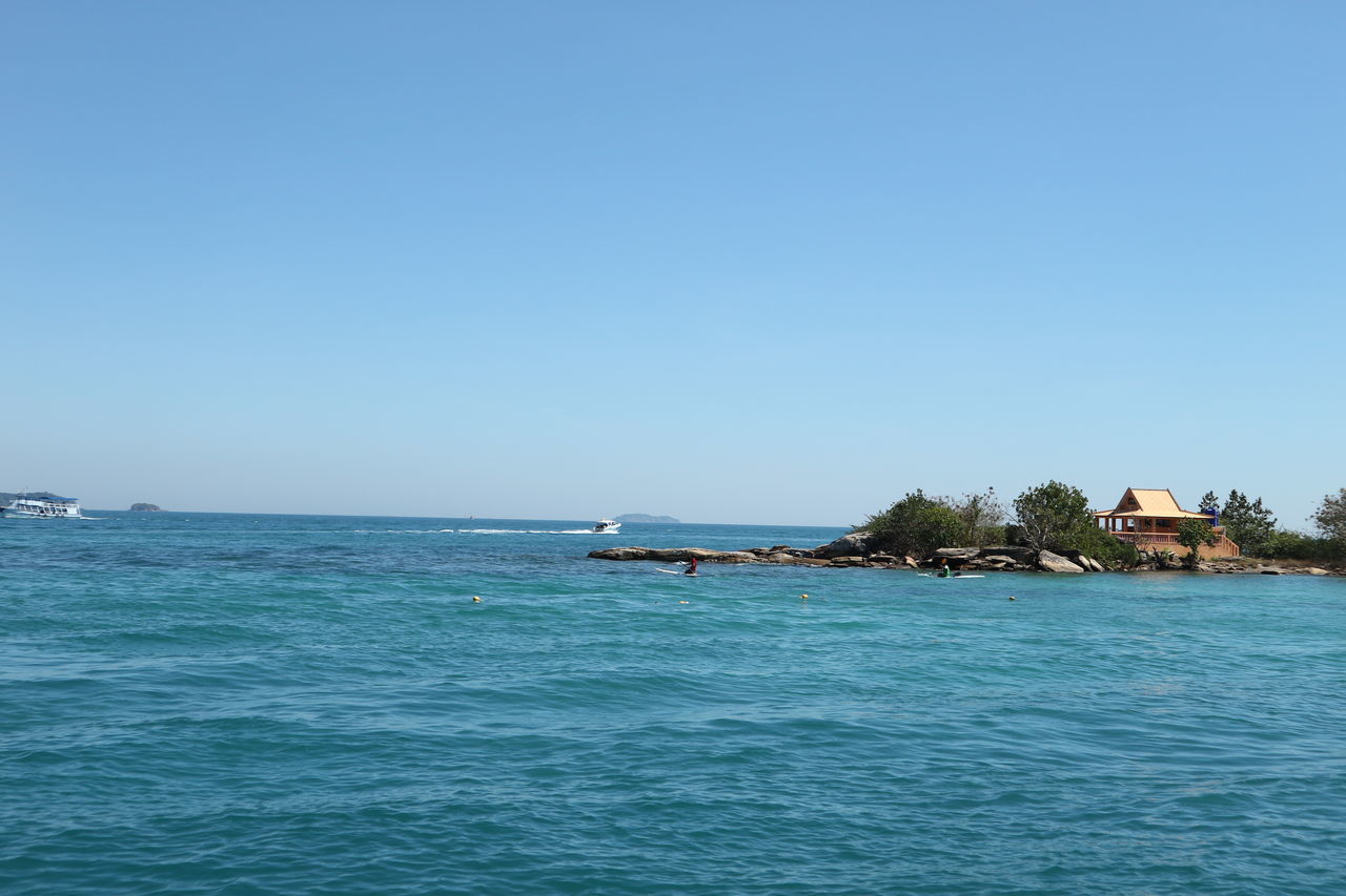 SCENIC VIEW OF SEA AND BUILDINGS AGAINST CLEAR SKY