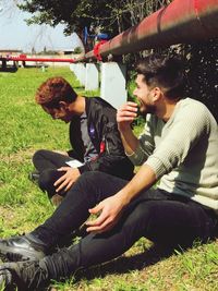 Young man using mobile phone while sitting on grass