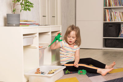 Child playing on the floor in dinosaurs in the room. development in the game. 