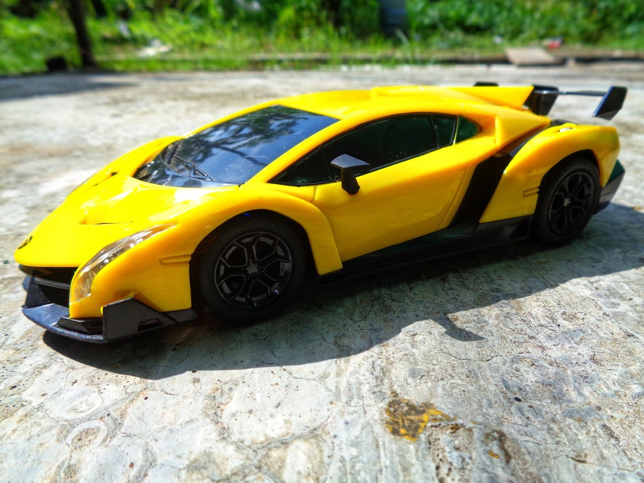 YELLOW TOY CAR ON STREET