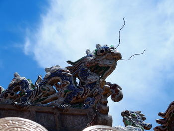 Low angle view of statue against cloudy sky