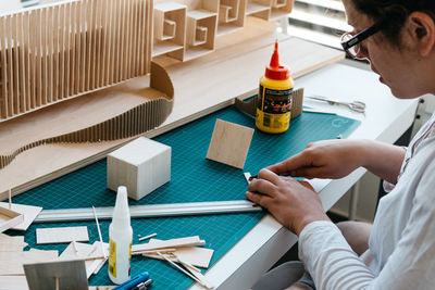 High angle view of young man working on table in workshop