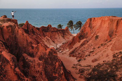 Scenic view of rock formations in sea against sky