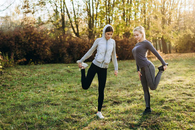 Morning fitness in the park. two young girls are doing exercises.