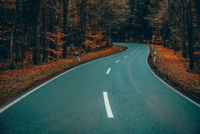 Road amidst trees in forest during autumn