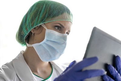 Unrecognizable female nurse using a digital tablet while standing in a hospital.