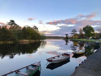 Boats moored on lake against sky