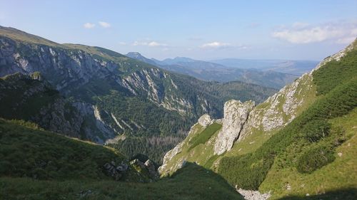 Scenic view of valley and mountains against sky