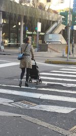 Rear view of woman walking on road