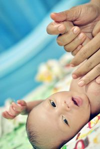 Tilt image of cropped hands of mother massaging new born baby