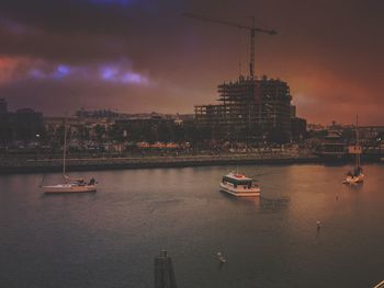 Boats sailing in river at dusk