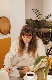 Woman home office and distance remote working. a young female businesswoman sitting at a desk 