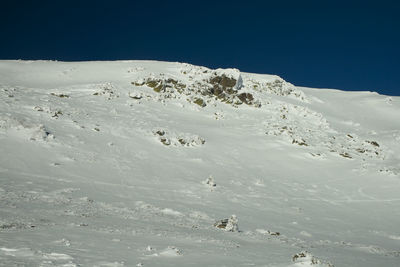 Scenic view of snowcapped mountains against clear blue sky