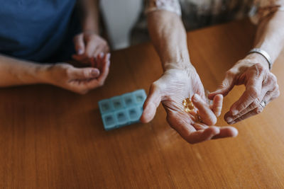 High angle view of senior woman with vitamins in hand at home