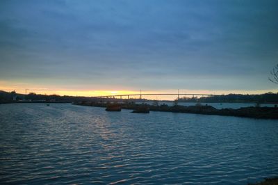 Bridge over sea against sky during sunset