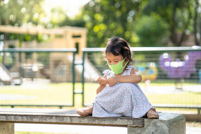 Girl sitting on bench in park