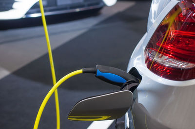 Close-up of electric car being charged on street