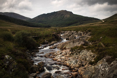 Scenic view of river amidst mountains against sky