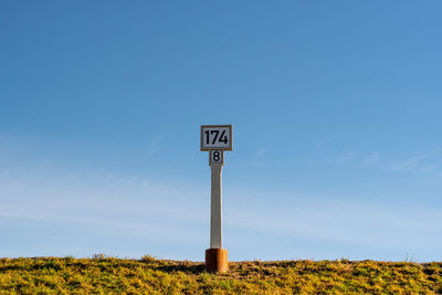 Low angle view of windmill against clear blue sky